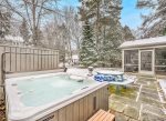 Daisy Cottage has a beautiful backyard setting with a picnic table on the patio and the relaxing hot tub